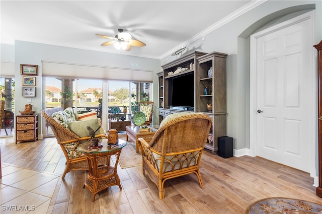 living room with crown molding, a wealth of natural light, and light hardwood / wood-style flooring