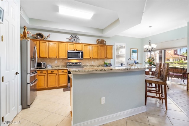 kitchen with light tile patterned floors, plenty of natural light, stainless steel appliances, and a center island with sink