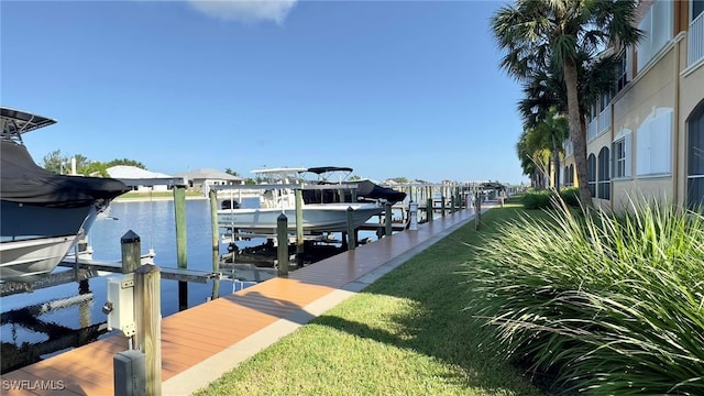 dock area with a water view and a yard