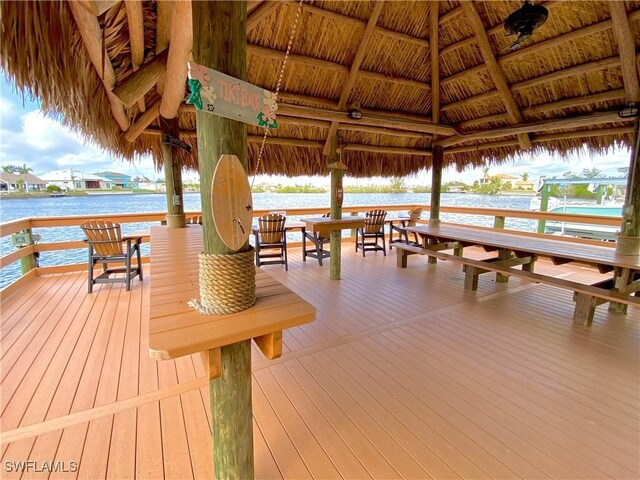 view of dock with a gazebo and a deck with water view