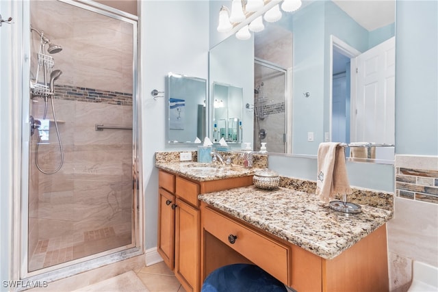 bathroom featuring a chandelier, tile patterned floors, vanity, and a shower with shower door