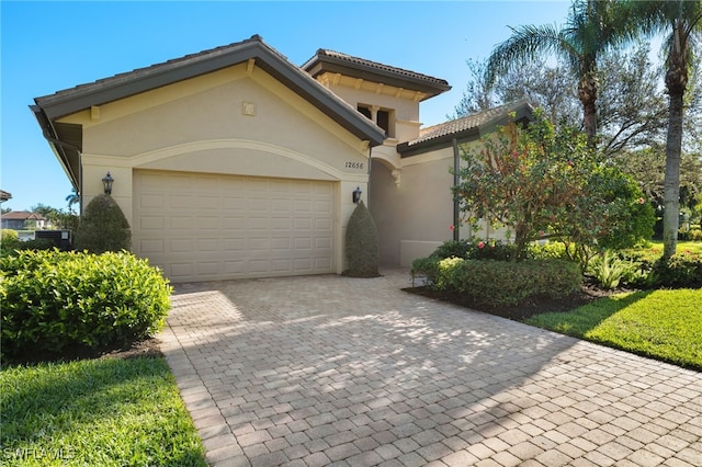12656 Grandezza Cir, Estero, FL 33928 - mediterranean / spanish-style home with decorative driveway, stucco siding, a garage, and a tile roof