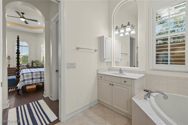 bathroom featuring tiled bath, ceiling fan, vanity, and hardwood / wood-style flooring