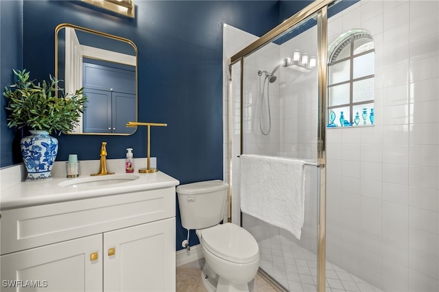 bathroom featuring tile patterned flooring, vanity, toilet, and walk in shower