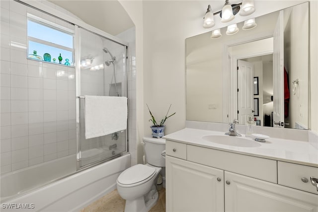 full bathroom featuring vanity, bath / shower combo with glass door, and toilet