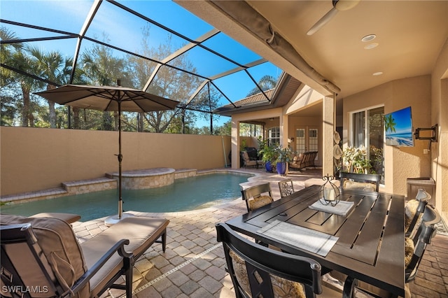 view of swimming pool featuring a jacuzzi, a patio, ceiling fan, and a lanai