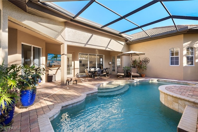 view of pool featuring glass enclosure and a patio area