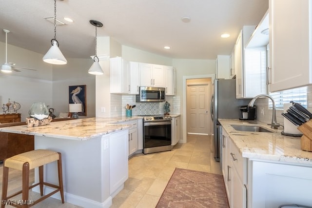 kitchen with kitchen peninsula, stainless steel appliances, white cabinetry, and sink