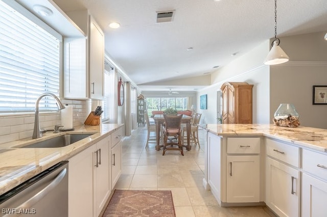 kitchen featuring dishwasher, sink, backsplash, lofted ceiling, and white cabinets