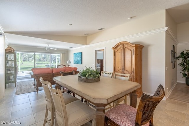 dining area featuring a textured ceiling, ceiling fan, light tile patterned floors, and lofted ceiling