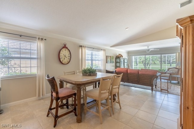 tiled dining space with ceiling fan and lofted ceiling