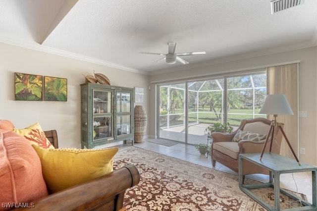 living room featuring tile patterned floors, ceiling fan, and ornamental molding