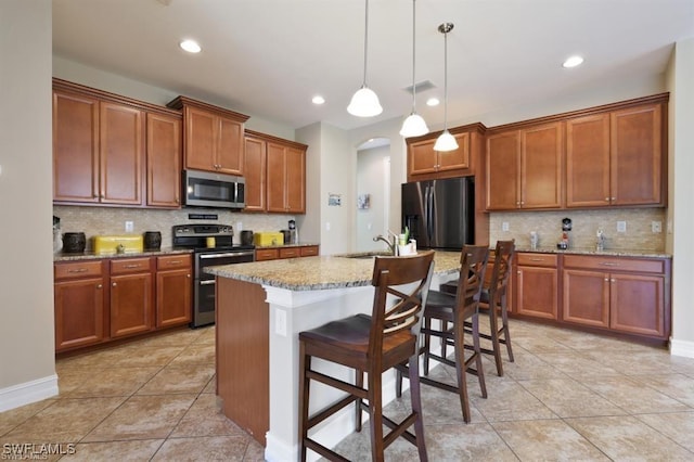 3290 Banyon Hollow Loop, North Fort Myers, FL 33903 - kitchen with appliances with stainless steel finishes, arched walkways, backsplash, brown cabinets, and recessed lighting
