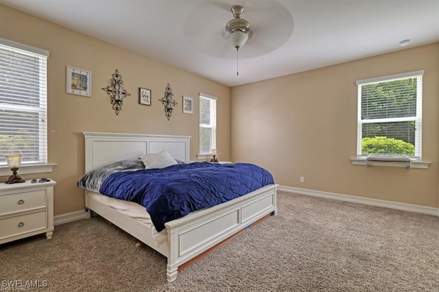 carpeted bedroom featuring ceiling fan and multiple windows