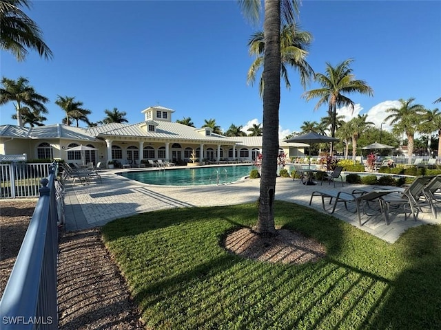 community pool with a patio and a lawn