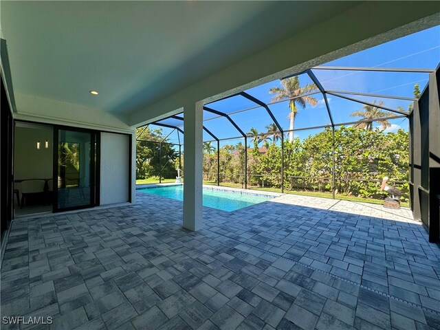 view of swimming pool with a patio and glass enclosure