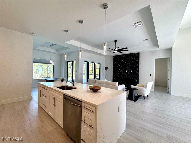 kitchen with stainless steel dishwasher, a healthy amount of sunlight, sink, and an island with sink