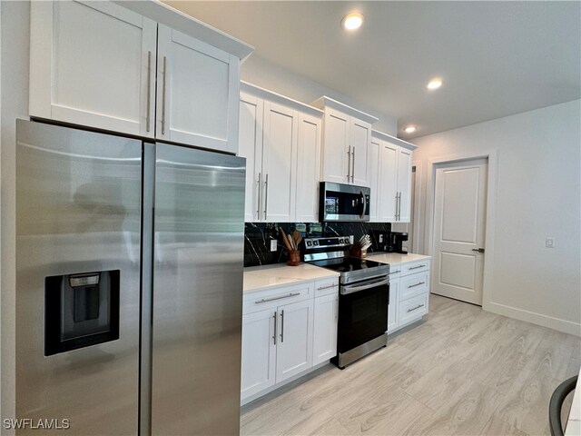 kitchen featuring white cabinets, decorative backsplash, and stainless steel appliances