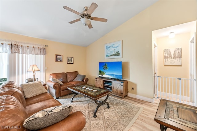 living room featuring ceiling fan, lofted ceiling, and light hardwood / wood-style flooring