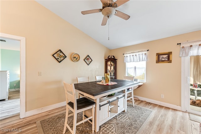 dining area with ceiling fan, vaulted ceiling, and light hardwood / wood-style flooring