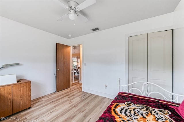 bedroom with ceiling fan, a closet, and light hardwood / wood-style floors