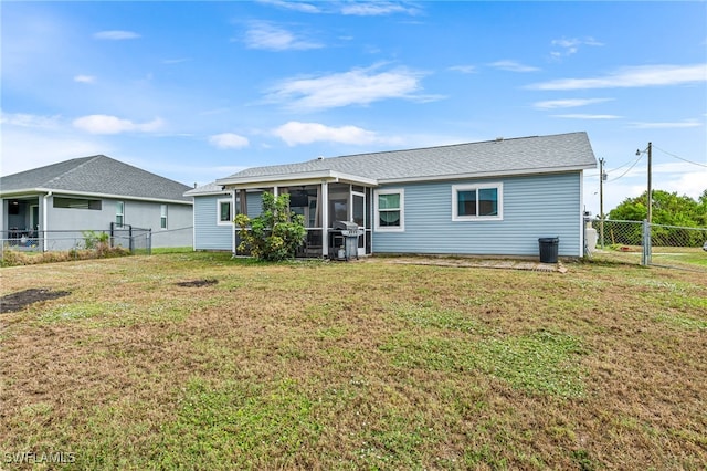 rear view of property with a yard and a sunroom