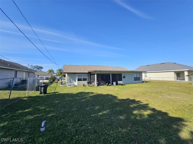 back of property with a yard and a sunroom