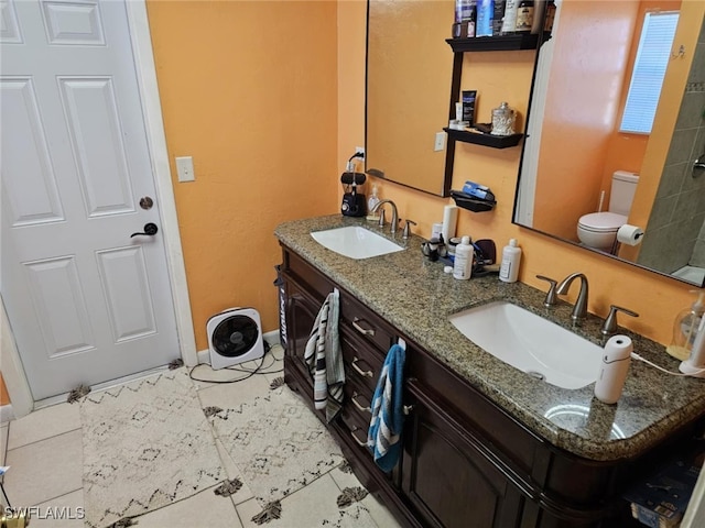 bathroom with tile patterned flooring, vanity, and toilet