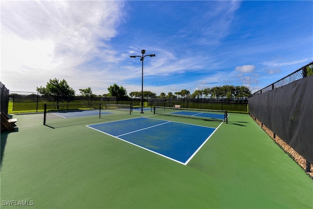 view of tennis court with basketball hoop