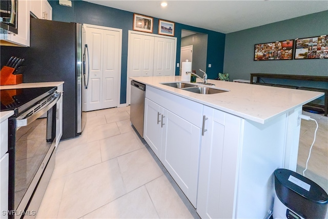 kitchen with appliances with stainless steel finishes, white cabinetry, and an island with sink