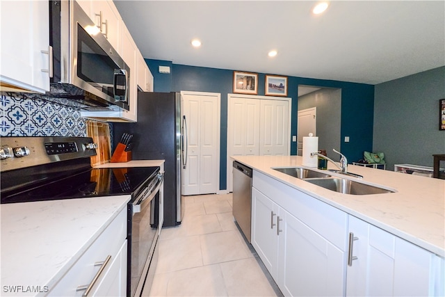 kitchen featuring white cabinets, light stone counters, sink, and appliances with stainless steel finishes