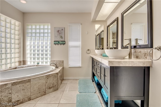 bathroom featuring tile patterned flooring, vanity, and tiled tub