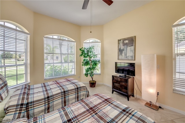 tiled bedroom with multiple windows and ceiling fan