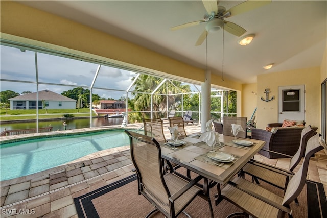 view of swimming pool featuring ceiling fan, a lanai, an outdoor living space, a patio area, and a water view