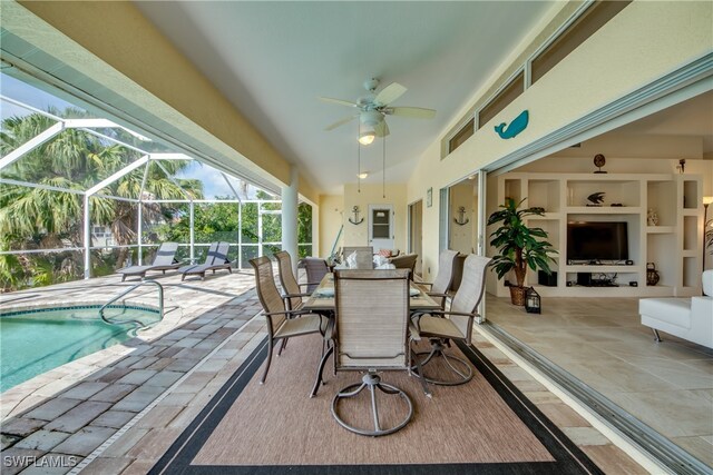 view of patio featuring ceiling fan and glass enclosure