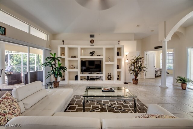 living room featuring ornate columns and light tile patterned floors