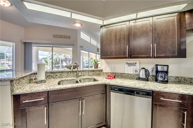 kitchen with light stone counters, stainless steel dishwasher, a healthy amount of sunlight, and sink