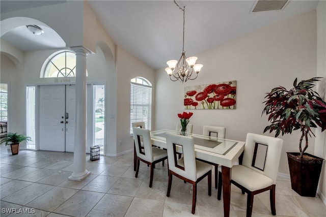 dining area with a towering ceiling, light tile patterned floors, and an inviting chandelier