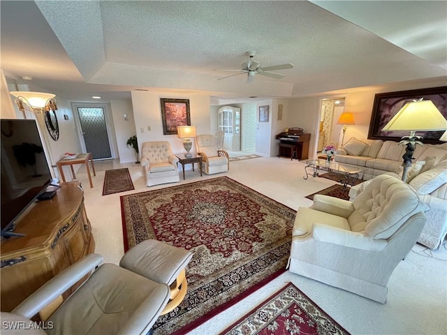 135 Quails Nest Rd Unit 1064, Naples, FL 34112 - carpeted living area featuring a textured ceiling, ceiling fan, a tray ceiling, and baseboards