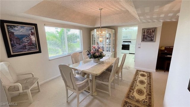 135 Quails Nest Rd Unit 1064, Naples, FL 34112 - dining space with a tray ceiling, a chandelier, baseboards, light carpet, and a textured ceiling