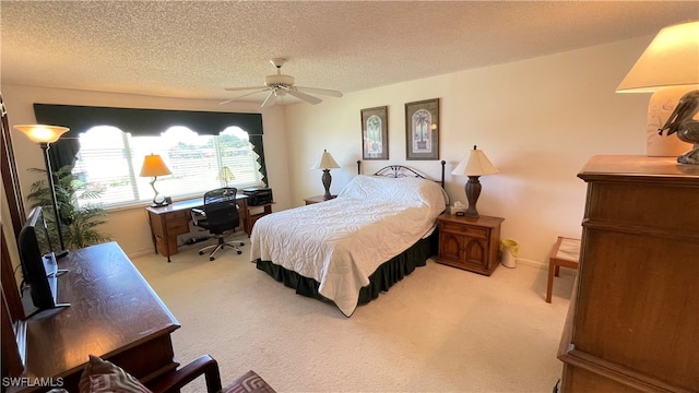 bedroom featuring ceiling fan, light colored carpet, and a textured ceiling