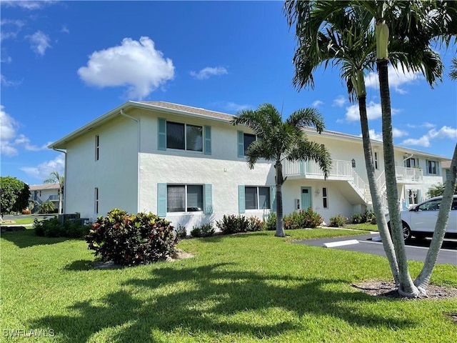 135 Quails Nest Rd Unit 1064, Naples, FL 34112 - view of front of property with stucco siding, a front yard, and uncovered parking