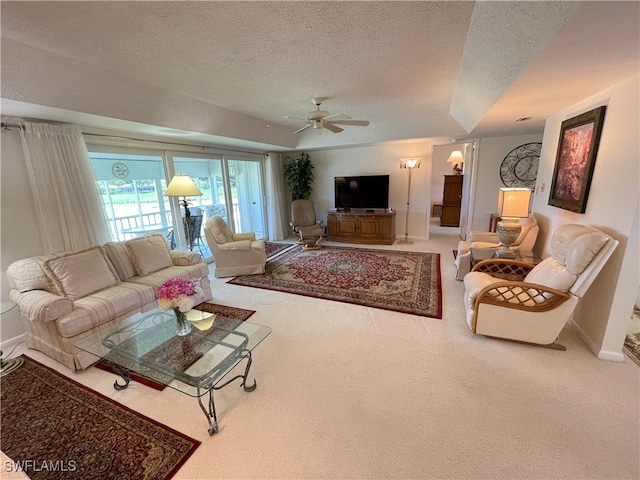 living room featuring ceiling fan, carpet, and a textured ceiling