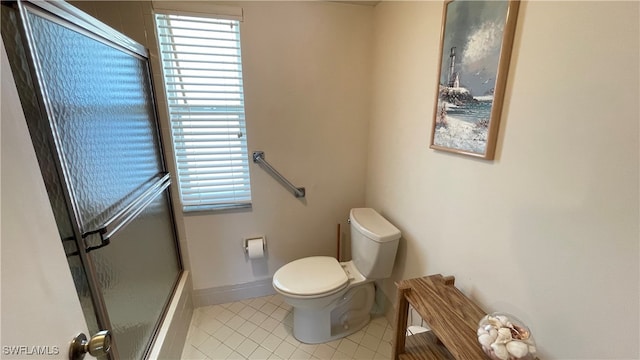 bathroom with toilet, tile patterned floors, and a shower with door