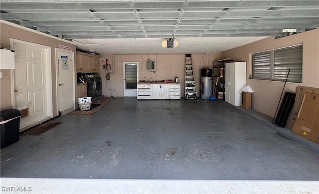 garage featuring a garage door opener, washing machine and dryer, and electric panel