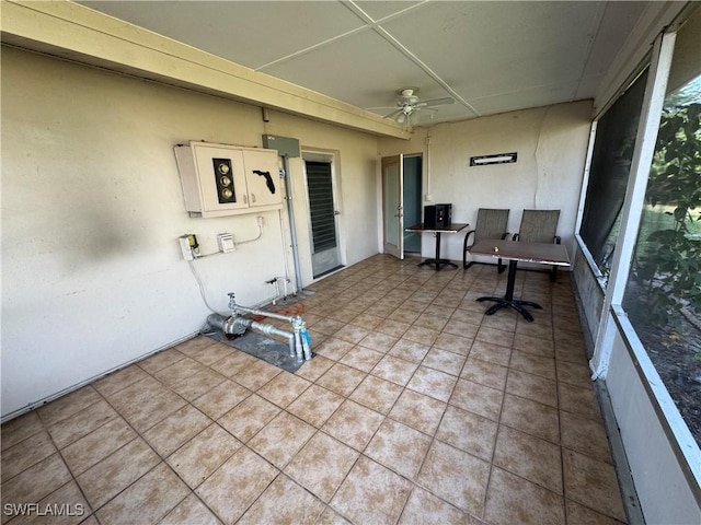 unfurnished sunroom with ceiling fan