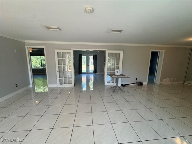 tiled empty room featuring ornamental molding and french doors