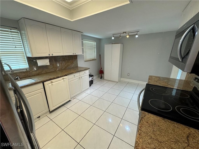 kitchen featuring light tile patterned floors, crown molding, white cabinetry, electric range oven, and decorative backsplash