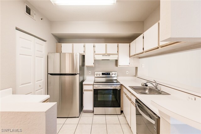 kitchen featuring light tile patterned floors, stainless steel appliances, white cabinetry, and sink