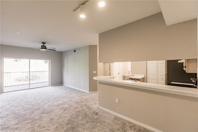 unfurnished living room featuring carpet, rail lighting, and ceiling fan